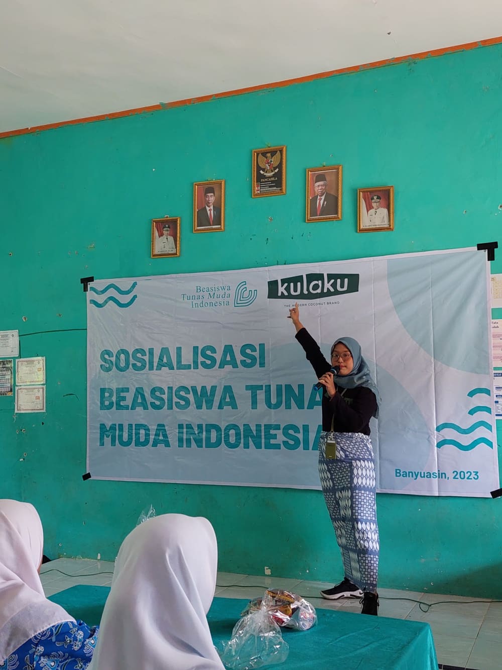 Gita presenting the BTMI scholarship to students in Banyuasin