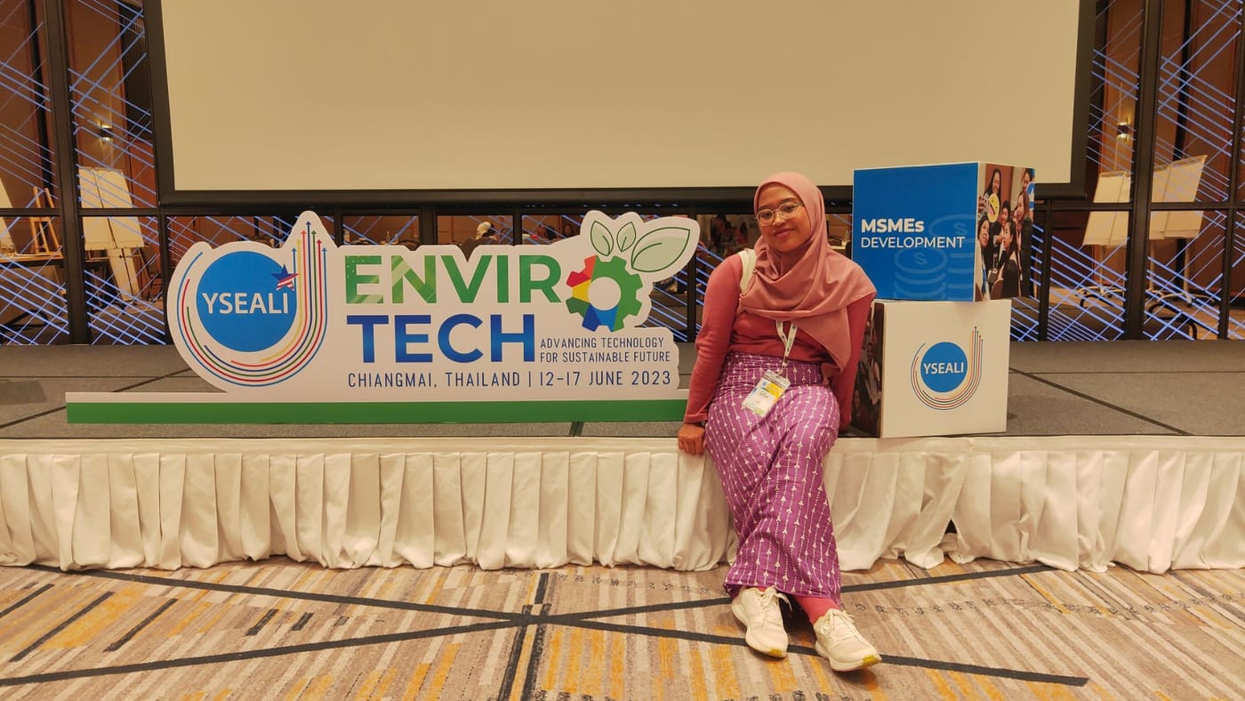 Gita sitting beside the YSEALI Enviro-Tech sign, Chiang Mai, Thailand, 12 to 17 June 2023